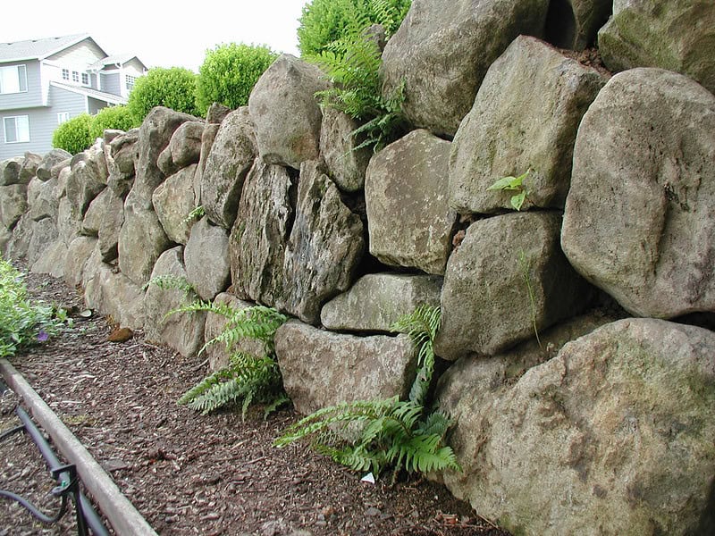 Kő támfal, erős és tartós, ideális kert és udvar határolására.