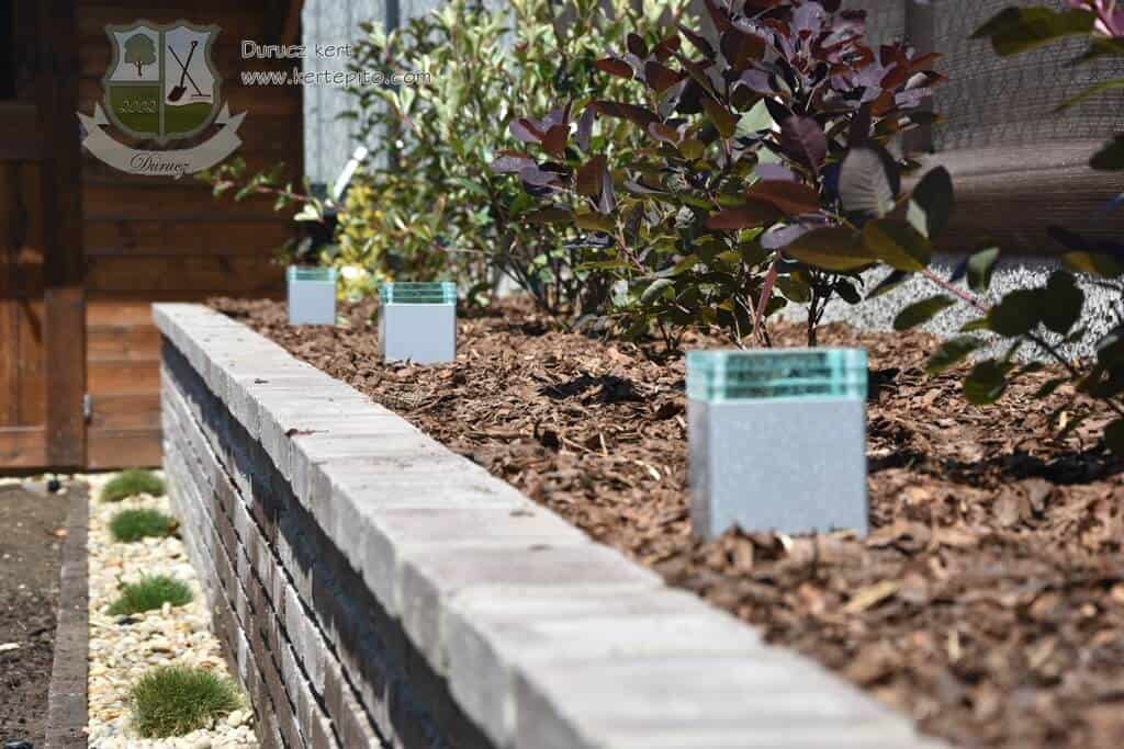 Álló növények ültetése a virágágyásban, friss talajban, gondos elrendezéssel.