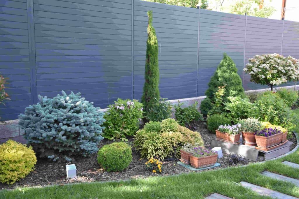 Álló kerítés a kertben, kék színű, modern kialakítással.